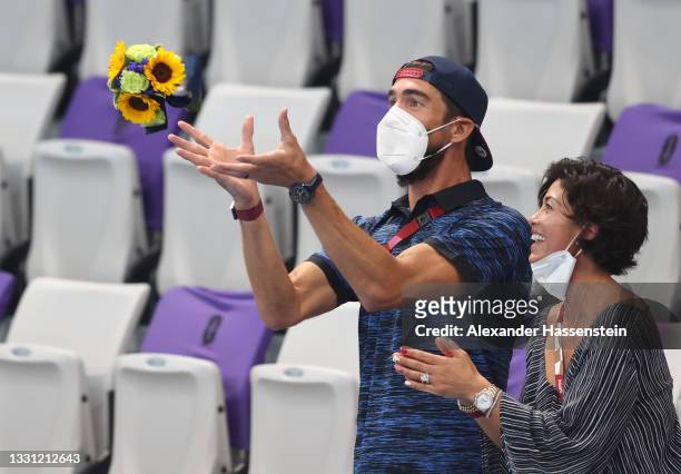 Michael Phelps catches a bouquet of flowers after the Women's 4 x 200m Freestyle Relay Final on day six of the Tokyo 2020 Olympic Games at Tokyo...