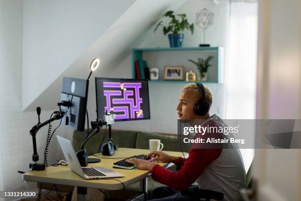 young mixed race gamer playing online in his bedroom - entertainment best pictures of the day may 24 2013 stockfoto's en -beelden