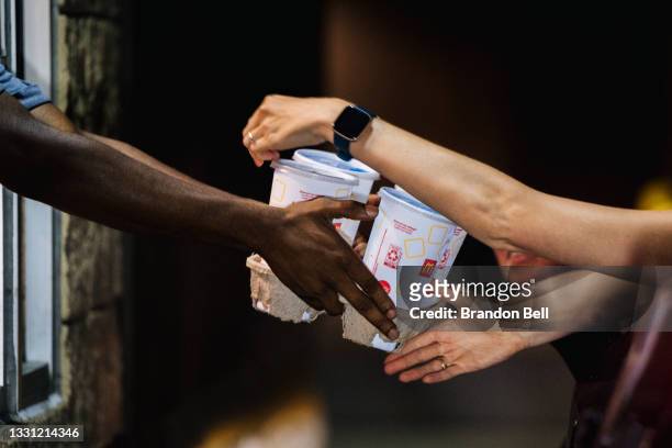 McDonald's employee hands a customer her food in a McDonald's drive-thru on July 28, 2021 in Houston, Texas. McDonald's Corp. Announced that sales...
