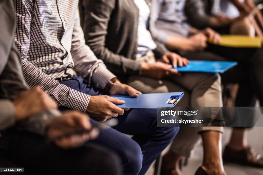 Group of unrecognizable candidates waiting for a job interview.