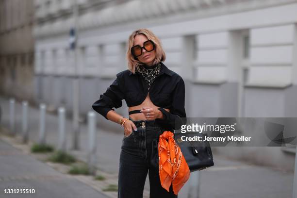 Karin Teigl wearing black Jacquemus top, grey Chanel vintage jeans and scarf, black leather bag, and Gucci shades on July 20, 2021 in Munich, Germany.