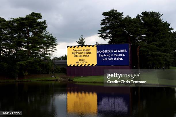 Weather warning sign is seen on the 18th hole during a weather-delayed first round of the Men's Individual Stroke Play on day six of the Tokyo 2020...