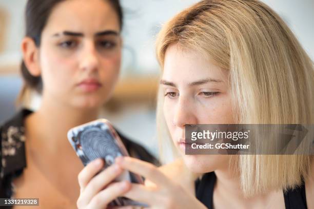 girlfriend frowning over internet blogpost - friends fighting stock pictures, royalty-free photos & images