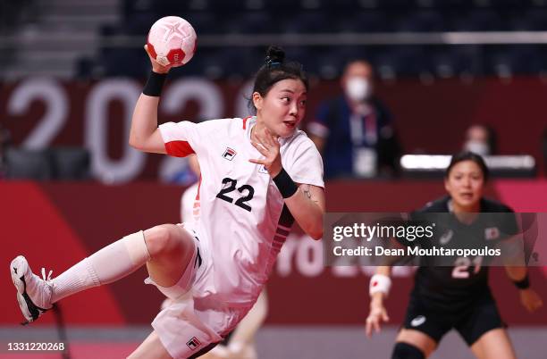 Gim Boeun of Team South Korea shoots and scores a goal as Ayaka Ikehara of Team Japan looks on during the Women's Preliminary Round Group A handball...