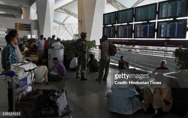 Passengers looking at the display board to know the status of their flight at Terminal 3 in Indira Gandhi International airport in New Delhi, India...
