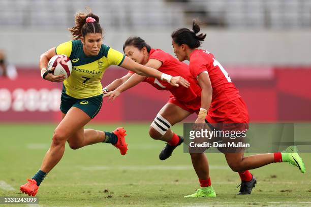 Charlotte Caslick of Team Australia evades the defense of Min Yang and Yaoyao Gu of Team China in the Women’s pool C match between Team Australia and...