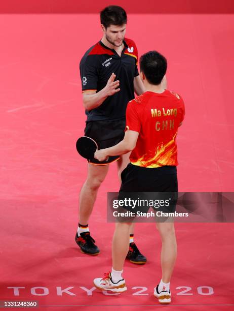 Dimitrij Ovtcharov of Team Germany and Ma Long of Team China shake hands after their Men's Singles Semifinals match on day six of the Tokyo 2020...