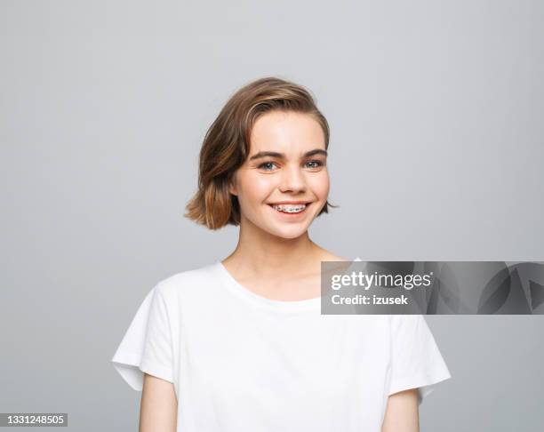 joven alegre con camiseta blanca - braces fotografías e imágenes de stock