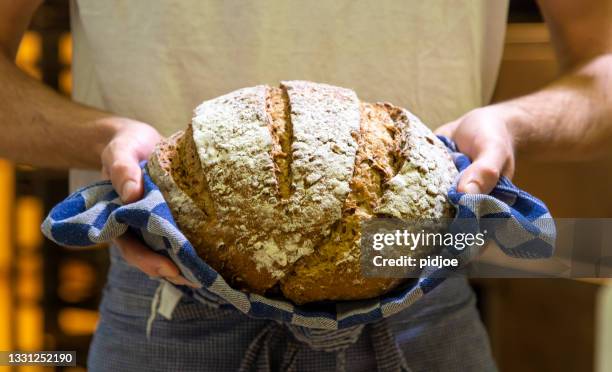 baker with fresh, warm bread. - soda bread stock pictures, royalty-free photos & images