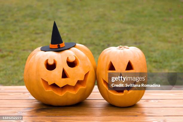 jack o'lantern , carved pumpkins on wooden table - witch hat stock pictures, royalty-free photos & images