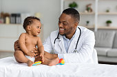 Portrait Of Smiling Black Doctor Making Check Up For Infant Baby Boy