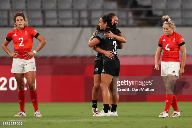 Abbie Brown and Natasha Hunt of Team Great Britain look dejected after defeat as Ruby Tui of Team New Zealand and Stacey Fluhler of Team New Zealand...