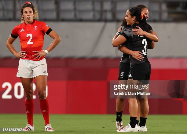 Abbie Brown of Team Great Britain looks dejected after defeat as Ruby Tui of Team New Zealand and Stacey Fluhler of Team New Zealand celebrate...