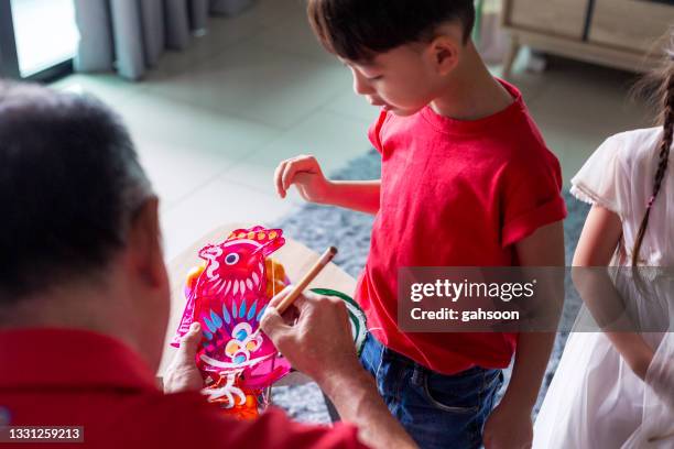 子供と紙から中国の提灯を作る大親 - 中秋節 ストックフォトと画像