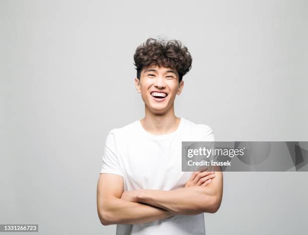 excited young man in white t-shirt - ecstatic asian stock pictures, royalty-free photos & images