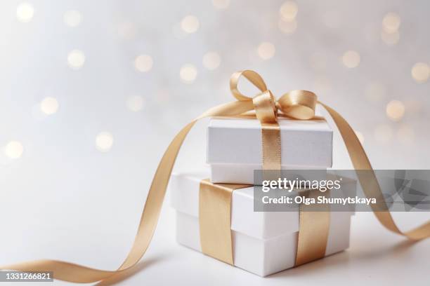two white gift box with gold ribbon on bokeh background - gift box stock pictures, royalty-free photos & images
