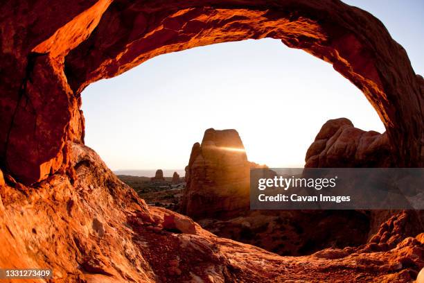 windows arch at sunset in arches national park near moab utah. - arches national park stockfoto's en -beelden