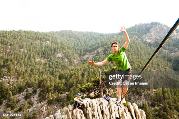 a male highliner walks the elephant buttresses highline in boulder canyon, colorado. - slackline foto e immagini stock