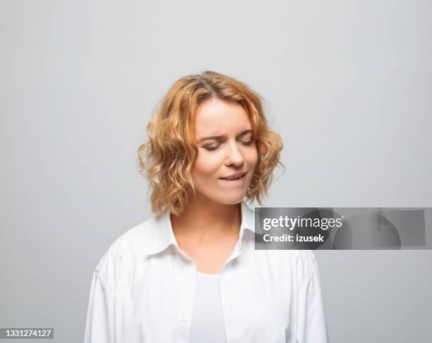 displeased young woman in white shirt - pain face portrait stockfoto's en -beelden