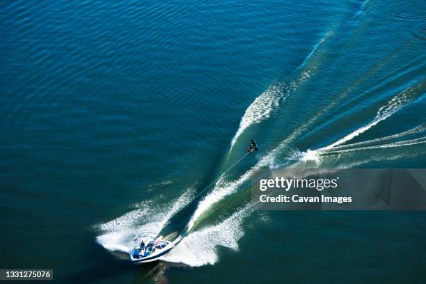 a athletic wakeboarder jumps the wake going huge on a calm day in idaho. - pend orielle lake stock pictures, royalty-free photos & images