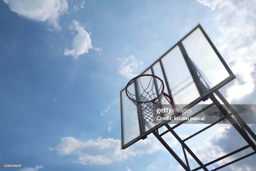Low angle view of an used basketball hoop against blue sky .