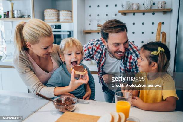 朝食を食べる幸せな家族。 - chocolate eating ストックフォトと画像