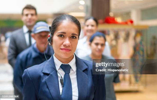 wachmann mit einer gruppe von arbeitern in einem einkaufszentrum - security guards stock-fotos und bilder