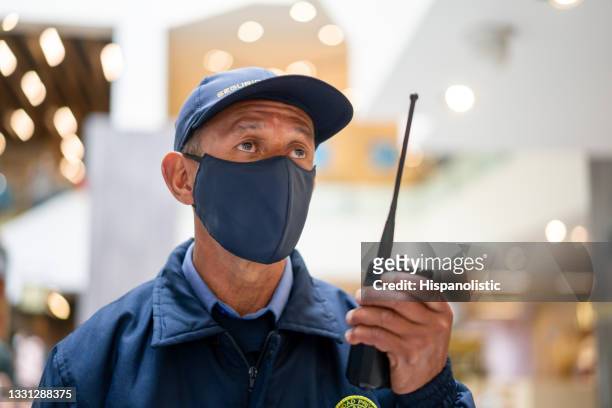 wachmann mit gesichtsmaske bei der arbeit in einem einkaufszentrum - security guard stock-fotos und bilder