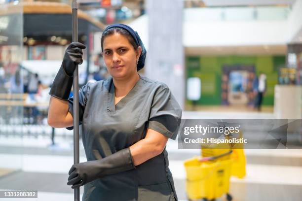cleaning lady mopping the floor while working at a shopping mall - reinier stockfoto's en -beelden