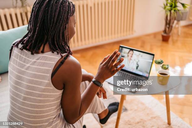 woman video conferencing with doctor on phone - online doctor stock pictures, royalty-free photos & images