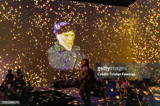 Visitors watch the immersive exhibition during the "Van Gogh: The Immersive Experience" press preview at Old Truman Brewery on July 29, 2021 in...