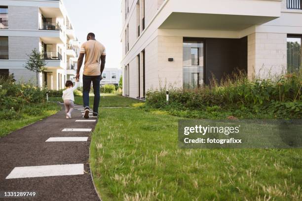 mignonne petite fille fait les premiers pas à la main du père - comté photos et images de collection