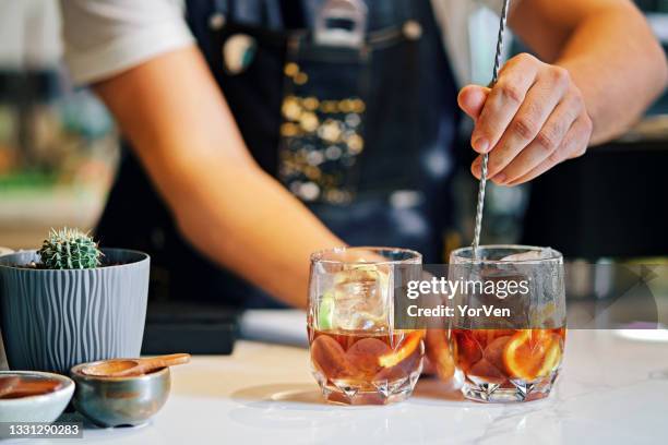 bartender mixing cocktails in bar - hands mixing a drink stock pictures, royalty-free photos & images