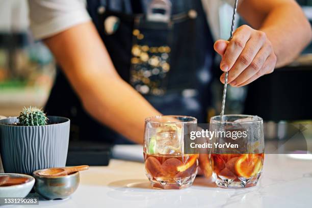 bartender mixing cocktails in bar - bartender stock pictures, royalty-free photos & images