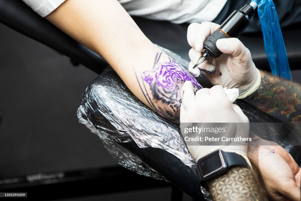 Closeup Of Male Tattoo Artist Tattooing A Tiger On A Young Mans Arm  High-Res Stock Photo - Getty Images