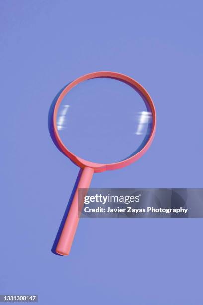pink magnifying glass on blue background - loupe stock pictures, royalty-free photos & images