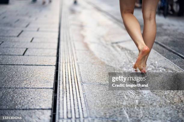 teenage girl walking in water running from the fountain on the street - salz mineral stock pictures, royalty-free photos & images