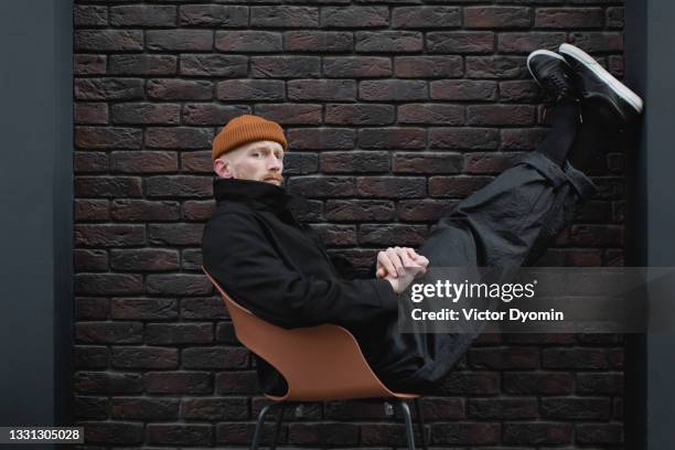 young stylish man in the black trendy outfit - mühelosigkeit stock-fotos und bilder