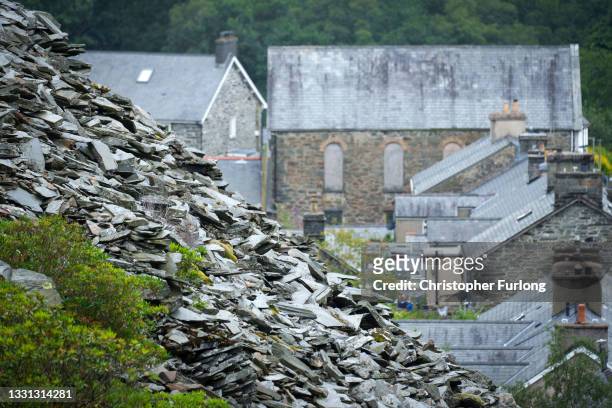 Homes with slated roofs stand in front of a slate mountain on July 29, 2021 in Blaenau Ffestiniog, United Kingdom. The North West Wales Slate...