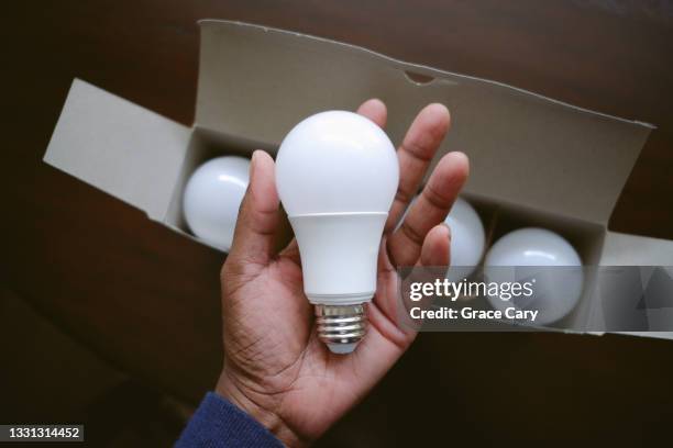 woman holds led light bulb - led ストックフォトと画像