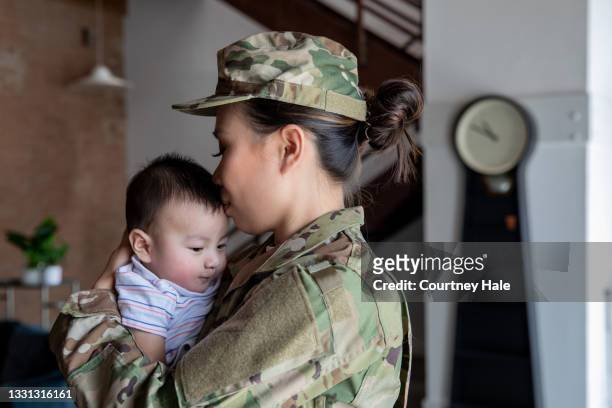 joven soldado tiene momento de vinculación con su hijo recién nacido antes de presentarse al servicio militar - filipino ethnicity and female not male fotografías e imágenes de stock