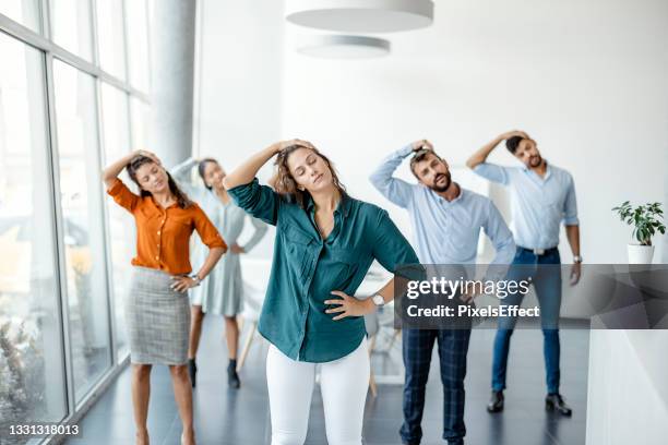 stretching exercise at workplace - office wellbeing stock pictures, royalty-free photos & images