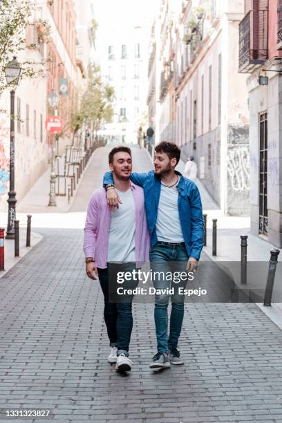 positive same sex couple walking on street - union gay bildbanksfoton och bilder