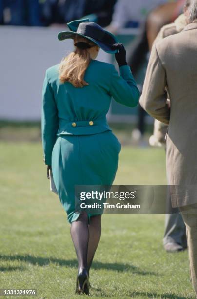 British Royal Sarah, Duchess of York, wearing a green suit and a black hat with green trim, attends the Seagram Grand National race meeting at the...