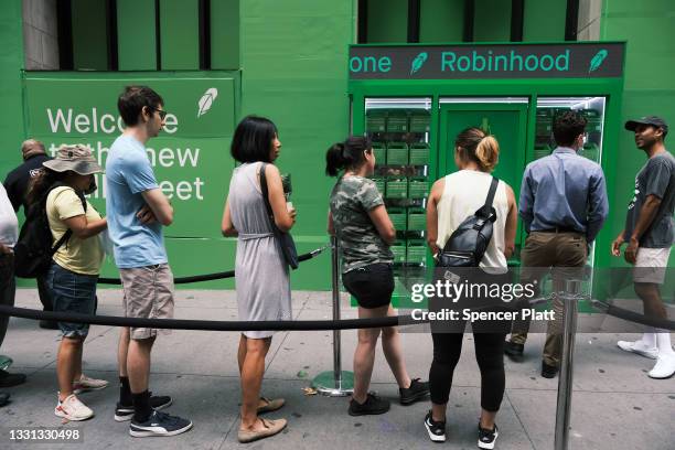 People wait in line for t-shirts at a pop-up kiosk for the online brokerage Robinhood along Wall Street after the company went public with an IPO...