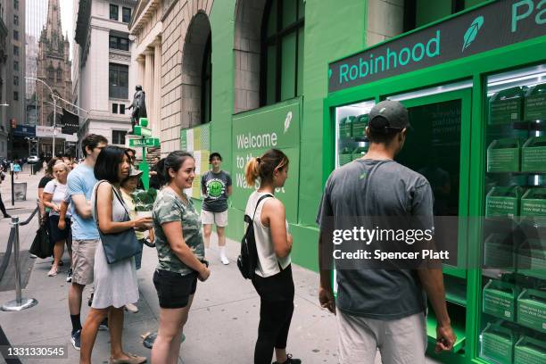 People wait in line for t-shirts at a pop-up kiosk for the online brokerage Robinhood along Wall Street after the company went public with an IPO...