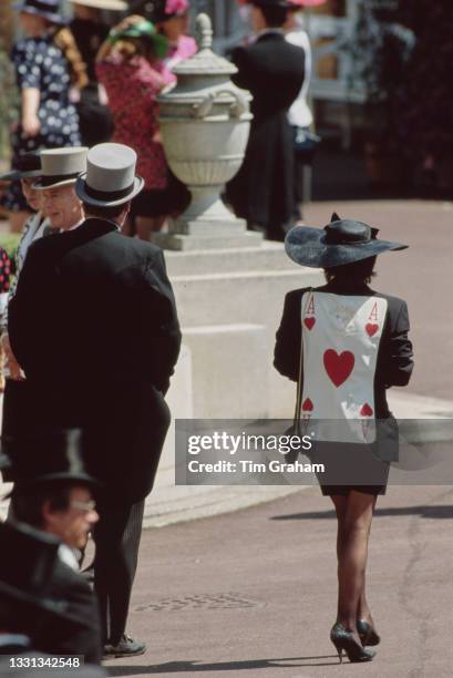 Unspecified racegoers, one wearing a jacket with an Ace of Hearts playing card on the back, attend the Royal Ascot race meeting held at Ascot...