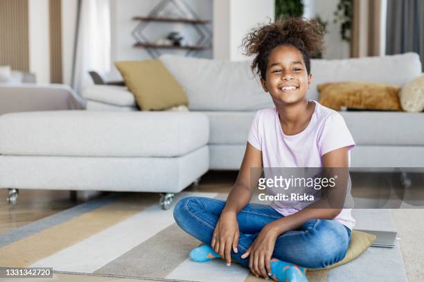 portrait of happy teenage girl sitting on the floor - small child sitting on floor stockfoto's en -beelden