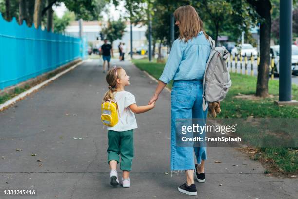 unrecognizable mother taking her daughter to school - parent stock pictures, royalty-free photos & images