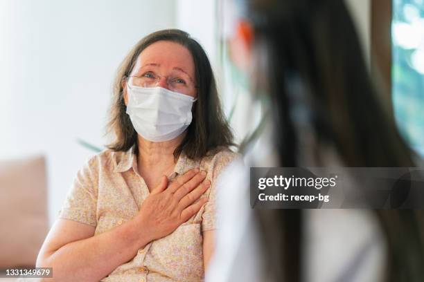 female doctor visiting her patient at her house - nurse listening to patient stock pictures, royalty-free photos & images